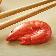 Load image into Gallery viewer, Shrimp-shaped dolomite chopstick rest in glossy red finish, displayed with wooden chopsticks on a neutral background.