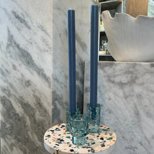 Load image into Gallery viewer, Hammered Glass Taper Holder, three aqua blue hammered glass candle holders displayed with blue taper candles on multicolor terrazzo pedestal against gray marble background. 