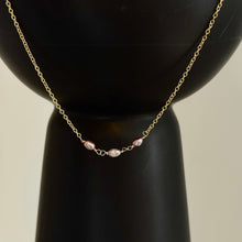Load image into Gallery viewer, Lavender Freshwater Pearl Necklace, close-up view of a delicate 14k gold-filled chain with three oval freshwater pearls in lavender and silvery tones, joined by wire-wrapped loops at the center, draped over a black vase.