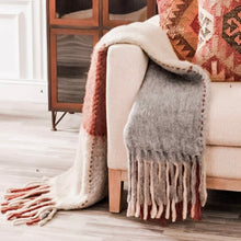 Load image into Gallery viewer, Handloom Woven Plaid Throw Blanket, gray, cream, and rust handloom woven plaid throw blanket with long multicolored fringe ends, draped over a cream chair beside patterned rust accent pillows. 