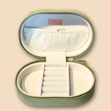 Load image into Gallery viewer, Garden Goose Oval Jewelry Box, open olive green oval case with zip closure, ivory interior with ring rolls, divided compartments, and elastic pocket in lid, on white background. 