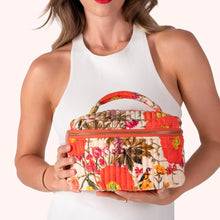 Load image into Gallery viewer, Quilted Cream Fine Flowers Vanity Case, cotton velvet quilted cosmetic case with orange, pink, and yellow floral and bird print, top handle and zipper closure, held in hands, against white background. 
