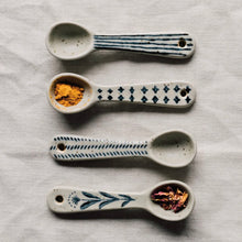 Load image into Gallery viewer, Element mini spoons, set of four, stoneware with assorted blue patterns including dash, stripe, floral, and geometric patterns, some holding spices, displayed on a white textured surface.