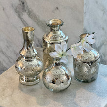 Load image into Gallery viewer, Silver Mercury Glass Etched Bud Vase, four assorted silver mercury glass etched bud vase styles, one displayed with a white floral stem on a light stone surface against gray marble background. 