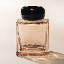 Load image into Gallery viewer, Poured NY Flesh &amp; Fuzz reed diffuser in clear bottle with peach-toned liquid and round black cap, displayed on a white background. 