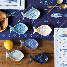 Load image into Gallery viewer, Aveiro stoneware fish-shaped pinch bowls set of 6 in assorted blue and white patterns on a wood surface with a blue fabric, lemon, and utensils.  