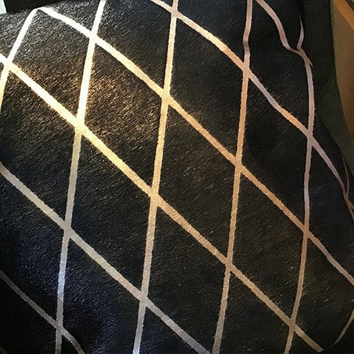 Close-up of black hide pillow  with a white geometric pattern.