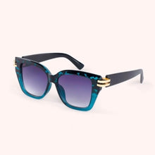 Load image into Gallery viewer, Philomena Tortoiseshell Sunglasses, oversized angular polycarbonate frames in dark teal tortoiseshell pattern with dark arms and metal gold-tones hinges, dark gradient lenses, angled side view against a white background. 