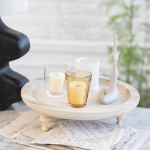 Load image into Gallery viewer, Footed Tray With Votive Holders, Vase &amp; Yoga Figure Set, round wood footed tray with three assorted glass votive holders holding white candles and a seated white metal yoga figure displayed in a styled setting. 