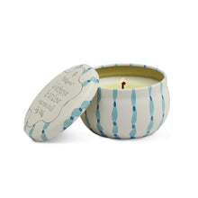 Load image into Gallery viewer, Round mini soy candle tin featuring blue vertical dotted stripe design with matching lid, shown burning on a white background.