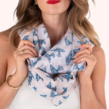 Load image into Gallery viewer, Watercolor Birds Infinity Scarf worn by model, cotton scarf with blue Scandinavian-style bird pattern on white fabric, close-up view against a white background.