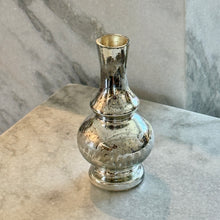 Load image into Gallery viewer, Silver Mercury Glass Etched Bud Vase, silver mercury glass etched bud vase with a rounded body, pedestal base, and subtle flared neck, displayed on a light stone surface against a gray marble background. 