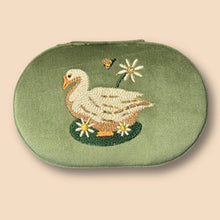 Load image into Gallery viewer, Garden Goose Oval Jewelry Box, olive green oval case with hand-embroidered goose, daisy flowers, and bee motif with subtle bead embellishment, zip closure, against white background. 