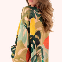 Load image into Gallery viewer, Exotic Leaves Kimono Jacket, close-up side view of lightweight kimono with tropical leaf print in dark green, teal, yellow, beige, and coral, shown on model against white background. 