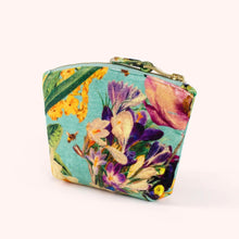 Load image into Gallery viewer, Spring Flora velvet mini pouch featuring colorful flowers in purple, yellow, and pink with green stems on a turquoise background, top zipper with gold-tone hardware and matching fabric pull, displayed on a white background. 