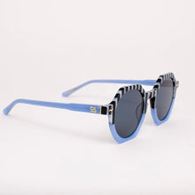Load image into Gallery viewer, Pool Boy Blues Sunglasses, oversized hexagon sunglasses with black-and-white striped top frames and arms, and dark tinted lenses with 100% UV protection shown at angled side view against white background.