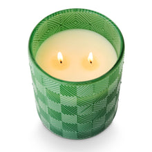 Load image into Gallery viewer, Jungle Green Magnolia Glass Candle, lit double-wick candle with white wax in jungle green glass vessel with raised diamond geometric pattern slightly overhead view against white background. 