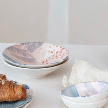 Load image into Gallery viewer, Abstract Design Stoneware Bowl, two assorted round stoneware bowls with abstract blue, blush, terracotta, and cream interior designs, stacked beside a matching dish holding a croissant and coordinating bowls on white surface. 