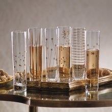 Load image into Gallery viewer, Assorted clear glass champagne flutes with gold decals on a gold tray with a glass top, with champagne poured into three of six flutes.