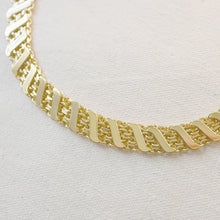 Load image into Gallery viewer, Close-up of a gold-plated brass bracelet showing its wide angled links with a textured diagonal pattern, displayed on a soft white textured background.