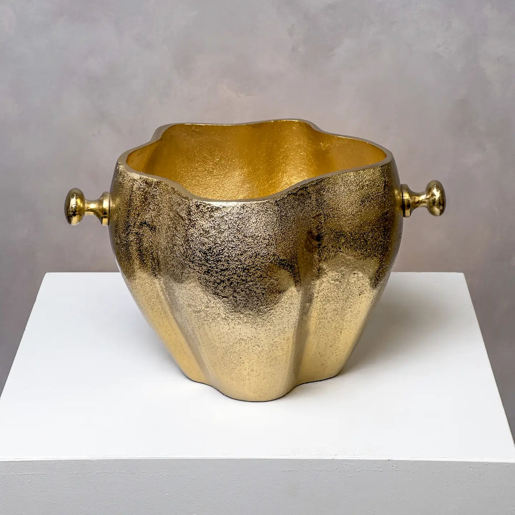 Sculpted wine cooler with a textured gold-finish and rounded side handles, displayed on a white surface against a gray background. 