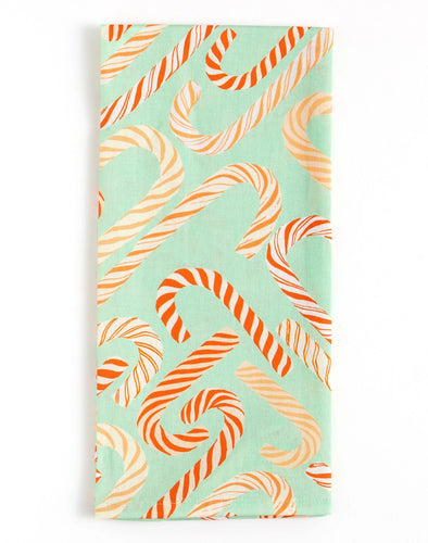 Cotton kitchen towel featuring a mint-green background with an allover red and cream candy cane pattern, displayed on a while background. 
