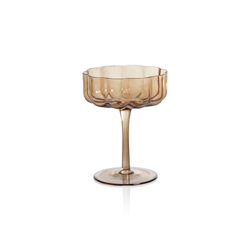 Handblown amber glass coup with a scalloped bowl and slender stem, displayed against a white background. 