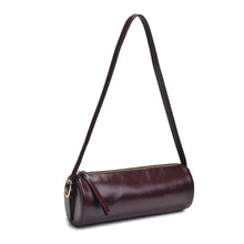Load image into Gallery viewer, Dark brown vegan leather cylindrical shoulder bag shown at a slight angel with a long slender strap and a top zipper pull, displayed against a white background. 