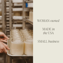 Load image into Gallery viewer, Person holding a tray of jars filled with white wax in a factory setting with text about a woman-owned, made-in-the-USA small business.