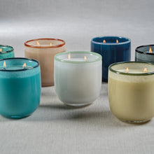 Load image into Gallery viewer, Serena St. Barth double-wick candles in assorted translucent glass containers with darker rims, displayed lit on a neutral surface.