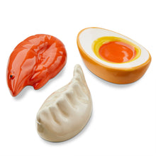 Load image into Gallery viewer, Assorted glossy dolomite chopstick rests including red shrimp, white dumpling, and halved boiled egg with yellow and orange center, displayed on a white background.