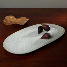 Load image into Gallery viewer, Aquarius Sage stoneware large oval platter with reactive glaze and concentric  line pattern, with figs and wooden utensils on a wood surface. 