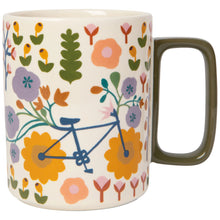 Load image into Gallery viewer, Petal Power Studio stoneware mug with rectangular olive-colored handle, multicolor floral pattern and bicycle design, displayed on a white background. 