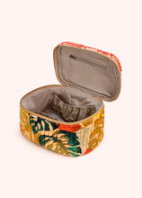 Load image into Gallery viewer, Quilted cotton velvet vanity case featuring a multicolor tropical leaf pattern in green, tan, yellow, and orange with a zip-around closure, shown open to reveal a soft beige satin interior with elastic compartments and a zip pocket, displayed on a white background. 