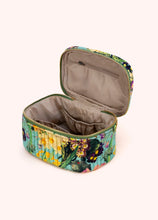 Load image into Gallery viewer, Quilted cotton velvet vanity case featuring a multicolor floral pattern in yellow, purple, green, and pink on a light turquoise background with a zip-around closure, shown open to reveal a soft beige satin interior with elastic compartments and zip pocket, displayed on a white background. 