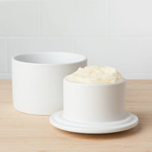 Load image into Gallery viewer, Matte round white stoneware butter crock with butter, base and lid shown on a light wood surface. 