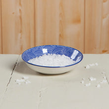 Load image into Gallery viewer, Blue Waves ceramic dipping bowl with blue dot pattern interior and white exterior, filled with coarse white salt, displayed on a white tabletop. 