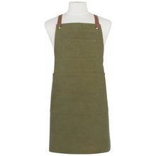 Load image into Gallery viewer, Olive Branch Mason cotton apron in olive green with front pockets, metal grommets, and structured design, front view, displayed on a mannequin. 