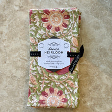 Load image into Gallery viewer, Zinnia Block Print Napkins, set of four, cotton napkins with hand block-printed floral pattern in coral and peach on an olive background, folded and wrapped with branded label, displayed on a marble surface.  