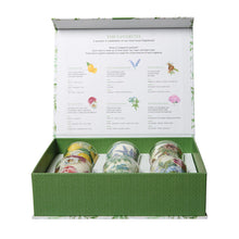 Load image into Gallery viewer, Favorite Fragrances votive sampler gift set featuring six glass votive candles with assorted botanical and fruit designs including lemons, lavender, florals, and birds, shown in an open green gift box with printed fragrance descriptions and graphics inside the lid, displayed on a white background.
