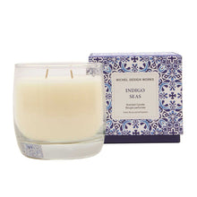 Load image into Gallery viewer, Michel Design Works Indigo Seas double-wick candle in a clear glass vessel with white wax, shown with blue and white tile-inspired patterned packaging box, displayed on a white background. 