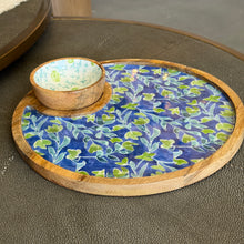 Load image into Gallery viewer, Azure &amp; Ivy round platter and bowl set shown at an angled view with blue and green botanical design, bowl with white interior featuring blue vines and green rose accents, with mango wood rims, displayed on a dark textured surface. 