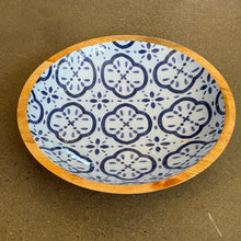 Load image into Gallery viewer, Amalfi Cucina shallow bowl with blue geometric floral pattern on white interior and mango wood rim displayed on a dark surface. 