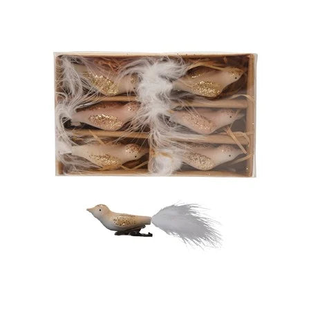 Set of six bird clip-on decorations in a storage box with dividers, next to a single clip-on bird ornament. Birds have a white and pink body with gold glitter ,and a white feather tail. A clip-on ,on the bottom for fastening . Against a white background. 