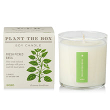 Load image into Gallery viewer, Fresh Picked Basil Plant The Box Candle, unlit white soy wax candle in clear glass jar with green label beside illustrated basil plant product box against white background. 