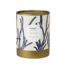 Load image into Gallery viewer, Dune Grass Coastal Candle, cream packaging with blue branch pattern and gold-toned rim and base, against white background. 