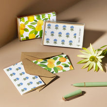 Load image into Gallery viewer, Block Print Mini Cards Box Set, two assorted watercolor-style designs including blue floral pattern and citrus fruit pattern on white textured felt paper cards with brown kraft envelopes and clear storage boxes, styled with flower and sage green pen on neutral surface. 
