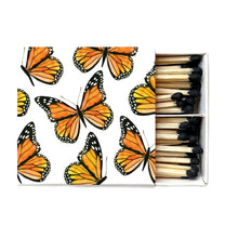 Load image into Gallery viewer, Monarch Boxed Matches, boxed wooden safety matches with watercolor orange monarch butterfly design on white sliding cover, black-tipped sticks, partially open, against white background. 