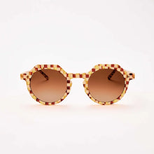 Load image into Gallery viewer, Georgie Toasted Moxie Checkered Sunglasses round acetate sunglasses with UVA/UVB protection, gradient amber-brown lenses, and brown, red, cream, and golden yellow checkered frames against white background. 