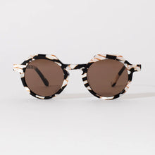 Load image into Gallery viewer, Georgie Cosmic Cowboy Sunglasses, round sunglasses with black, cream, and brown marbled frames, dark brown tinted lenses and 100% UVA and UVB protection against white background. 